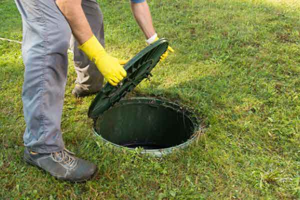 Man is opening a manhole lid