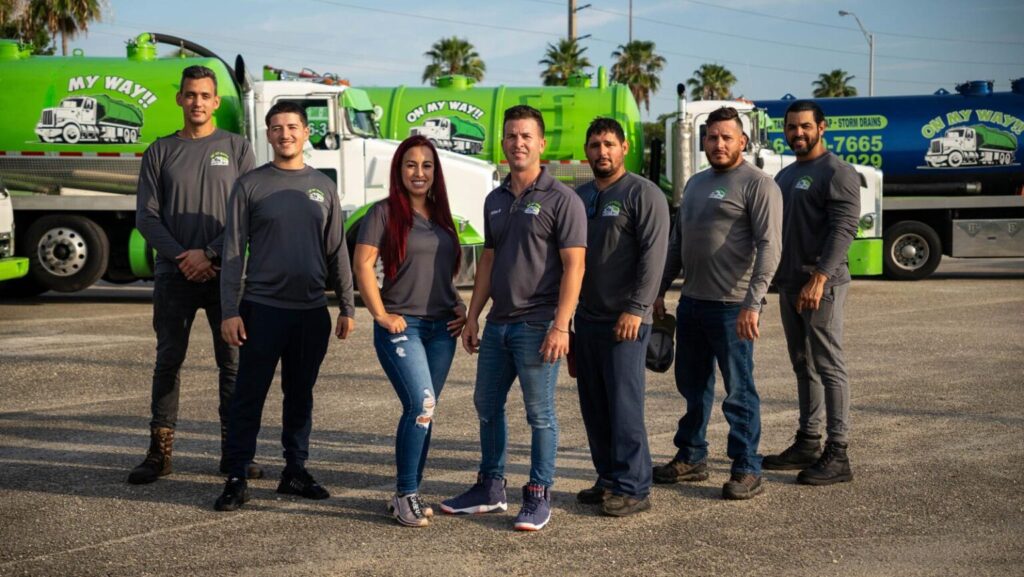 It’s a team in uniform standing before their green, branded service trucks